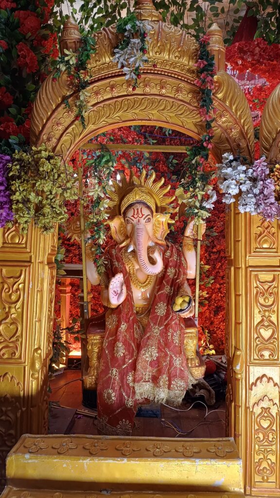 "Colorful idol of Lord Ganesha decorated with flowers during Ganesh Chaturthi celebration."